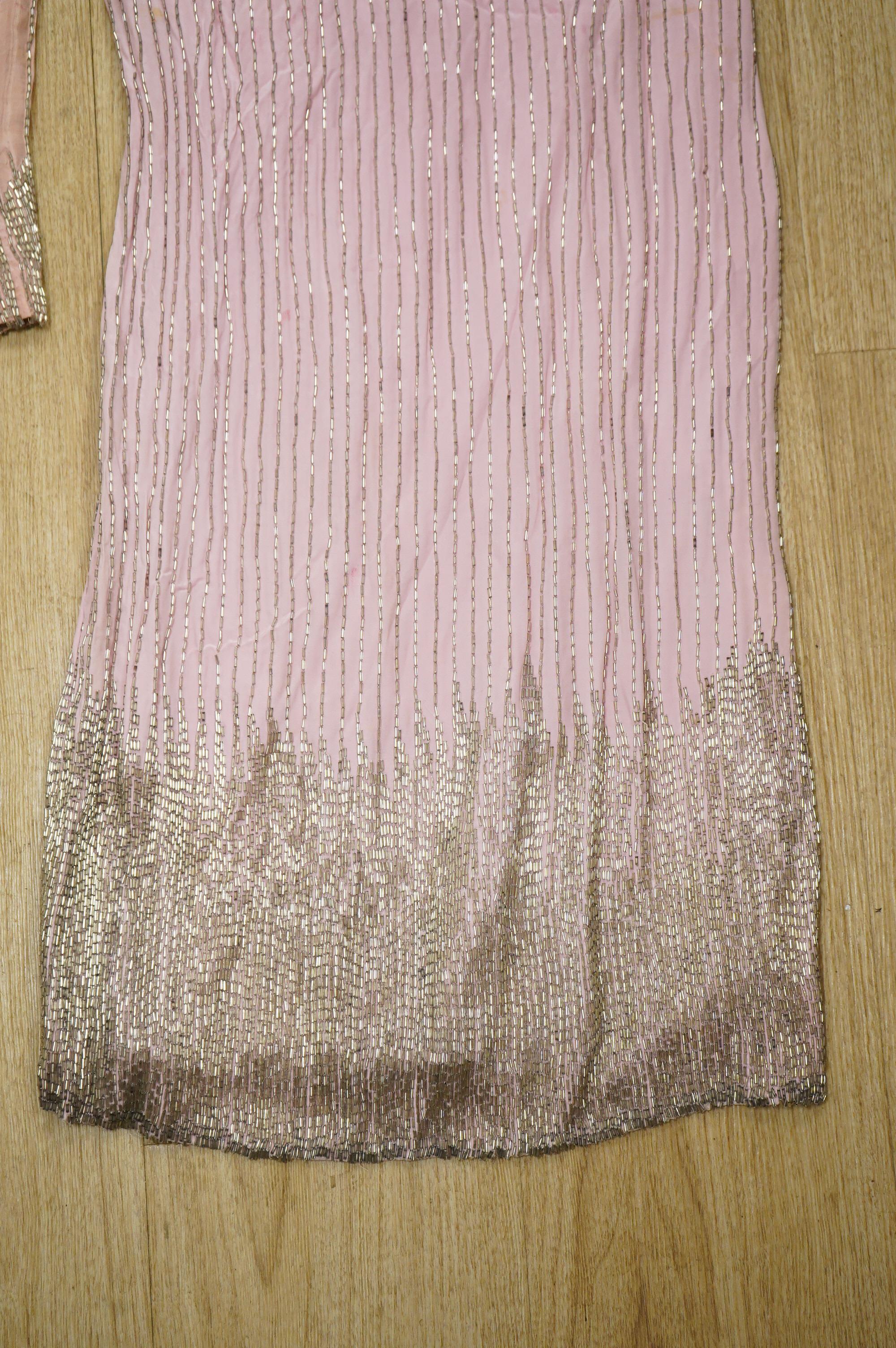 A mid to late 20th century pink and silver beaded evening dress-120cm long, with matching jacket, together with a green net beaded full length evening dress with mushroom lining and back split.